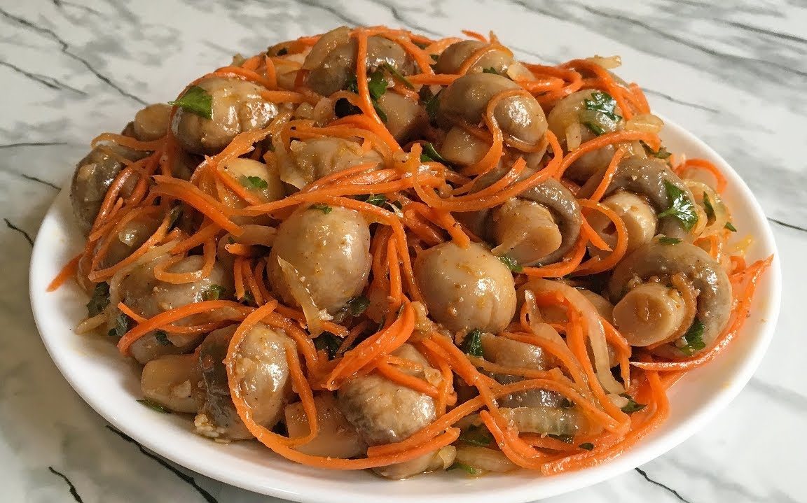 Отличная и вкусная еда с шампиньонами получается из отварных грибов и корейской моркови.
